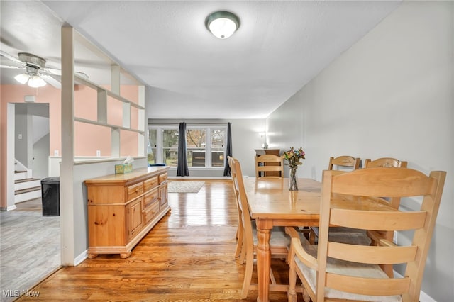 dining space featuring ceiling fan, light wood-type flooring, and vaulted ceiling