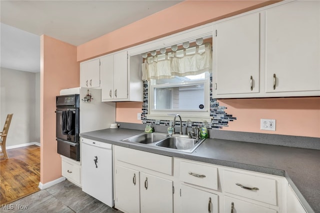 kitchen featuring white cabinetry, sink, oven, and hardwood / wood-style flooring