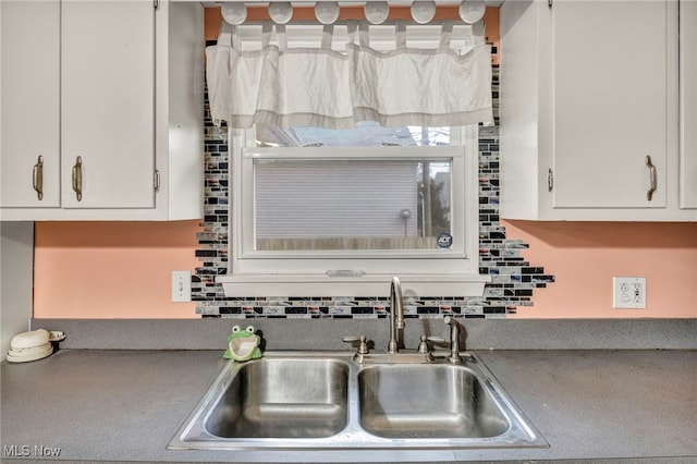 kitchen featuring white cabinetry, sink, and tasteful backsplash