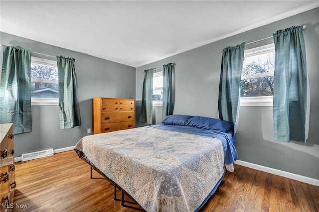 bedroom featuring multiple windows and hardwood / wood-style flooring