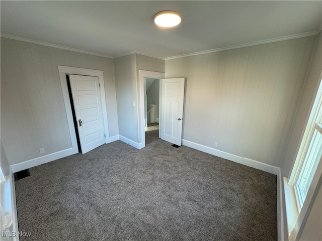 unfurnished bedroom featuring crown molding, a closet, and dark colored carpet