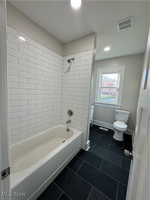 bathroom with toilet, tile patterned flooring, and tiled shower / bath