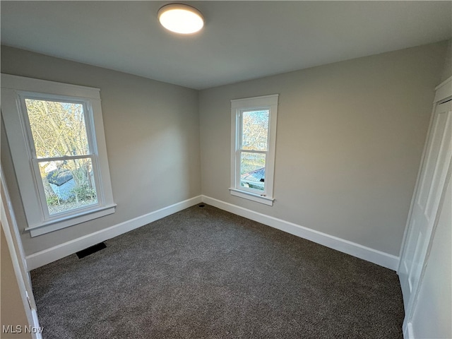 empty room featuring dark colored carpet