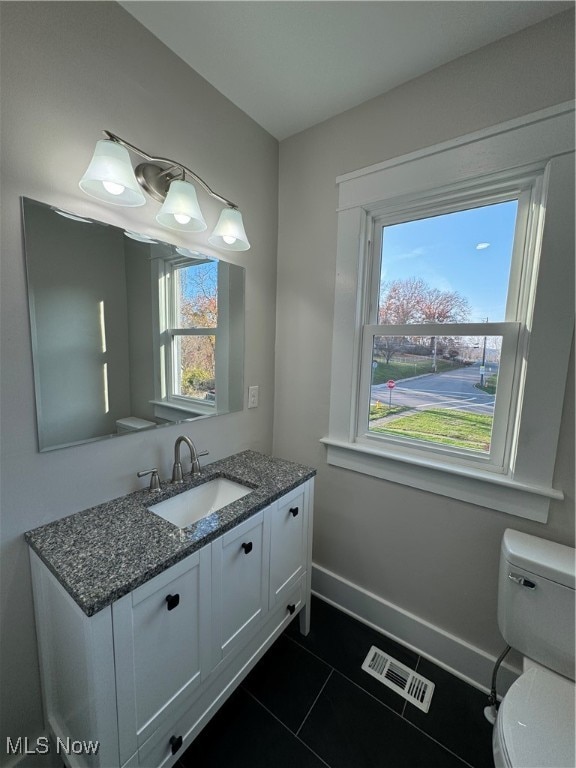 bathroom featuring tile patterned floors, vanity, and toilet