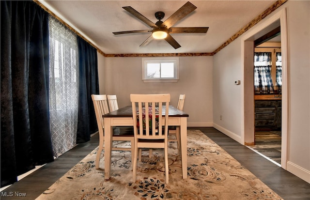 dining space featuring ceiling fan, crown molding, dark wood-type flooring, and a textured ceiling