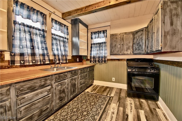 kitchen with gas stove, sink, wooden ceiling, beamed ceiling, and hardwood / wood-style flooring