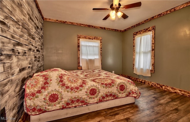 bedroom with hardwood / wood-style floors, ceiling fan, and ornamental molding