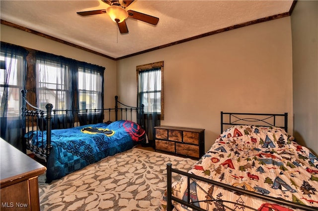 carpeted bedroom with ceiling fan, crown molding, and a textured ceiling