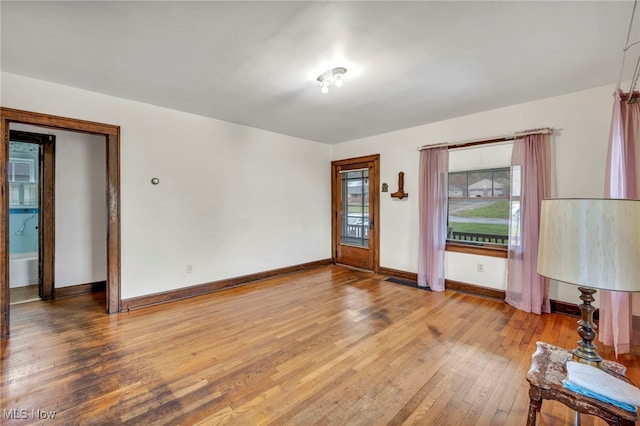 empty room featuring wood-type flooring and plenty of natural light