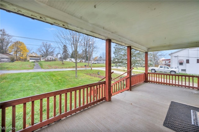 wooden deck with covered porch and a yard