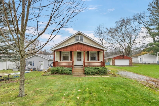 bungalow-style home featuring a porch, a garage, an outdoor structure, and a front yard