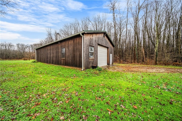 view of outbuilding featuring a garage and a yard