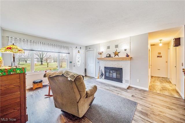 living room featuring hardwood / wood-style floors, a fireplace, and a textured ceiling