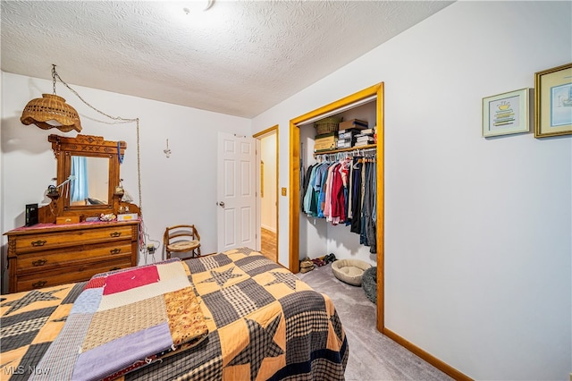 bedroom with a closet, carpet, and a textured ceiling