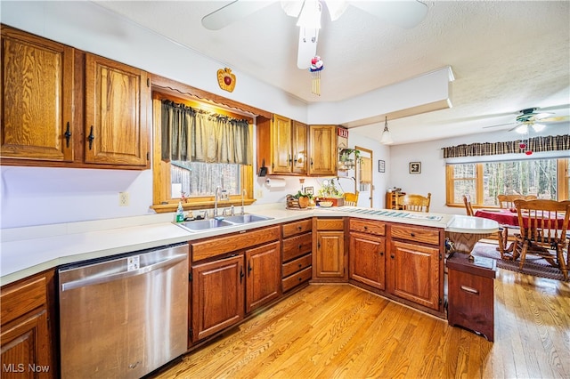 kitchen with dishwasher, light hardwood / wood-style floors, kitchen peninsula, and sink