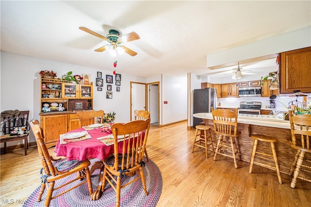 dining area featuring light wood-type flooring and ceiling fan