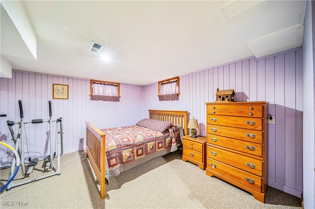 bedroom with carpet and wood walls