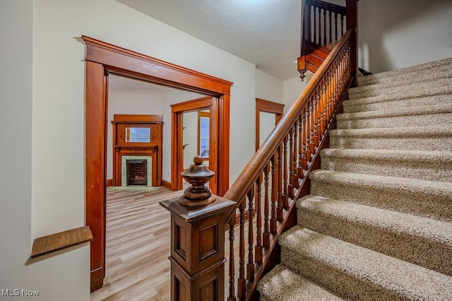 staircase featuring hardwood / wood-style floors and a textured ceiling