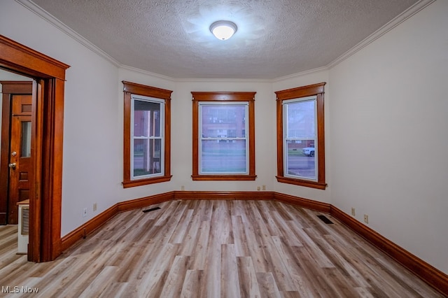 unfurnished room with light wood-type flooring, a textured ceiling, and ornamental molding