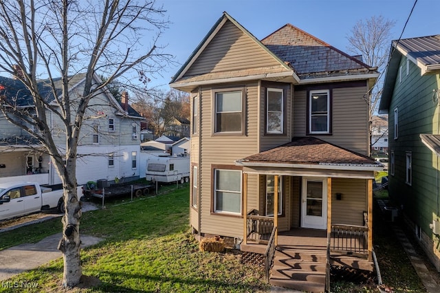 view of property featuring a porch and a front lawn