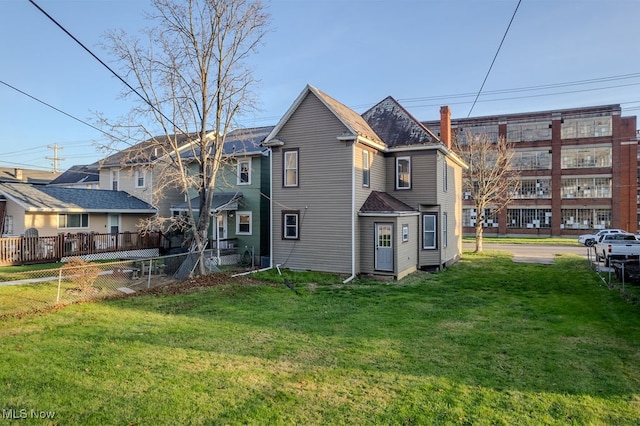 rear view of house featuring a yard