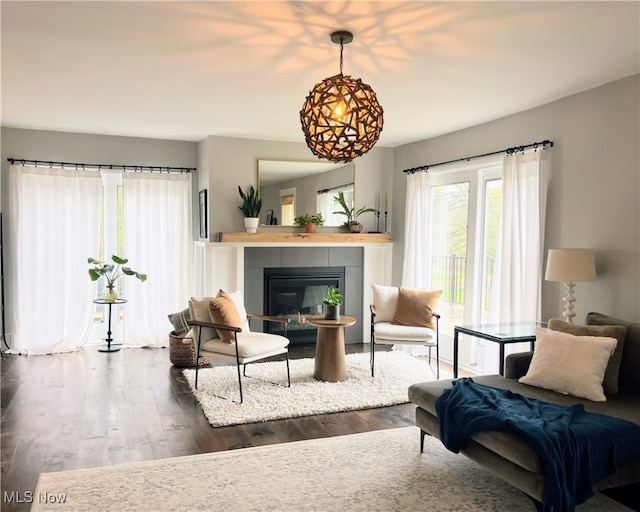 living room with dark hardwood / wood-style floors and a tiled fireplace