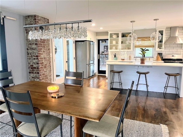 dining area featuring a barn door and dark wood-type flooring