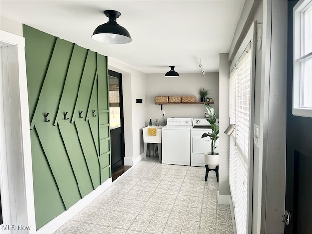 laundry room with light tile patterned floors, separate washer and dryer, and sink