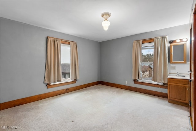 unfurnished bedroom with light carpet and sink