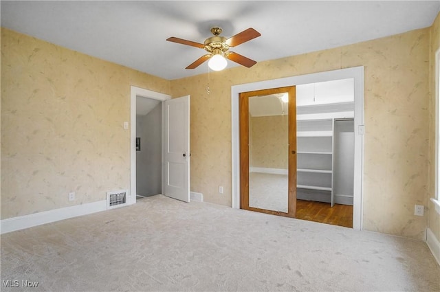 unfurnished bedroom with carpet flooring, ceiling fan, visible vents, and wallpapered walls