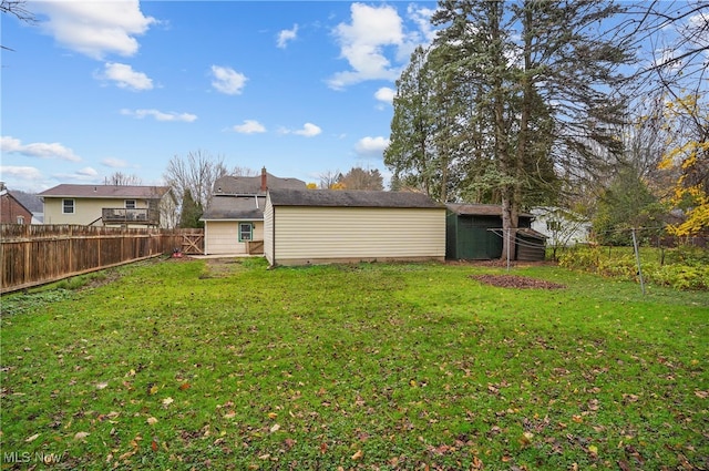 view of yard with a shed, an outdoor structure, and a fenced backyard