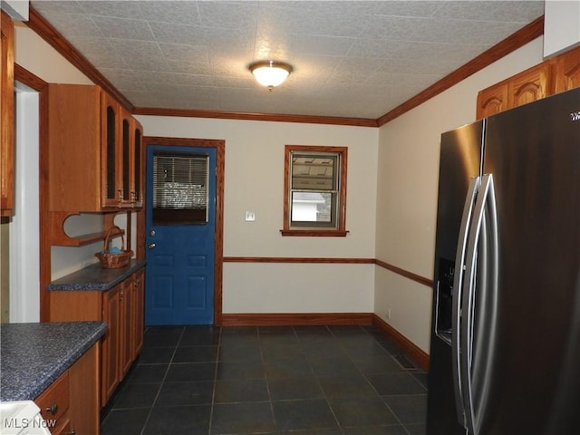 kitchen featuring brown cabinetry, stainless steel fridge with ice dispenser, dark countertops, glass insert cabinets, and crown molding