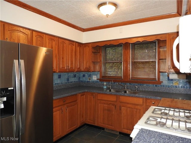 kitchen featuring crown molding, tasteful backsplash, dark countertops, a sink, and white appliances