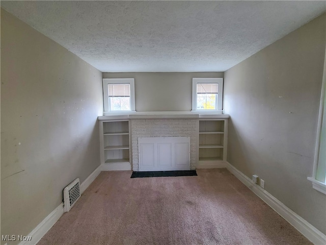 unfurnished living room featuring carpet flooring and a textured ceiling