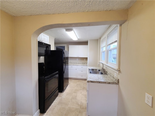 kitchen with a textured ceiling, sink, white cabinetry, and black appliances