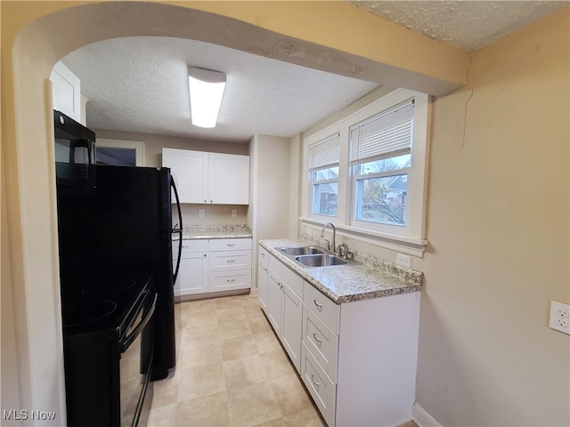 kitchen with sink, white cabinets, black appliances, and a textured ceiling