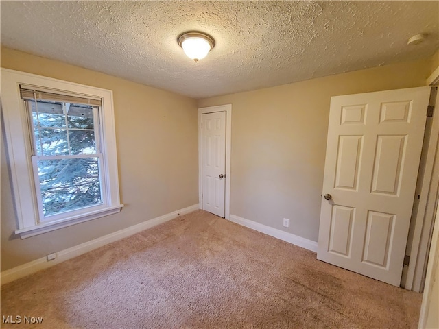 spare room with light carpet and a textured ceiling