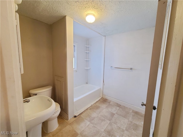 bathroom with a textured ceiling and toilet