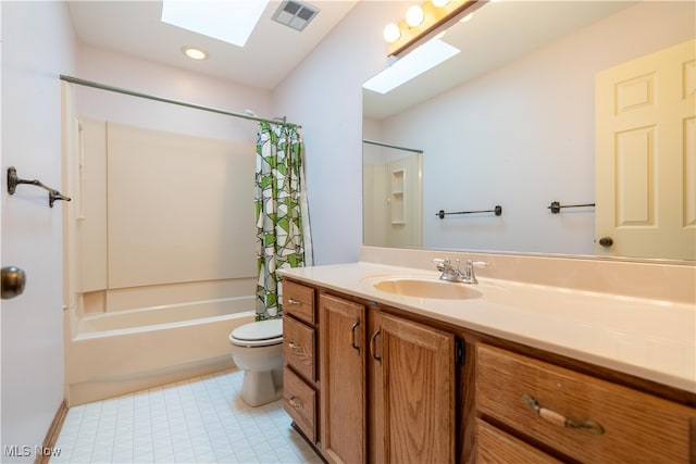 full bathroom with shower / tub combo, a skylight, vanity, tile patterned flooring, and toilet