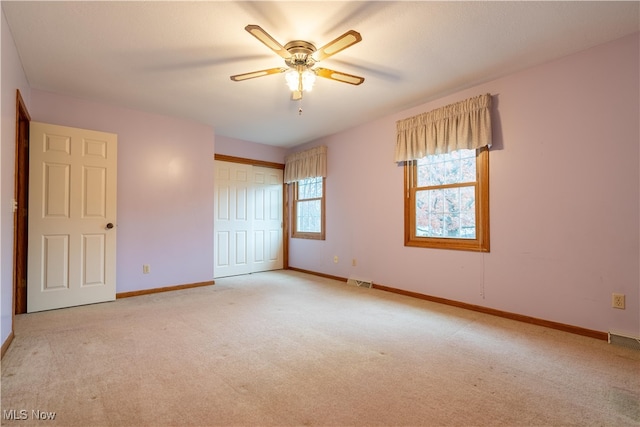 unfurnished bedroom with ceiling fan, a closet, and light carpet