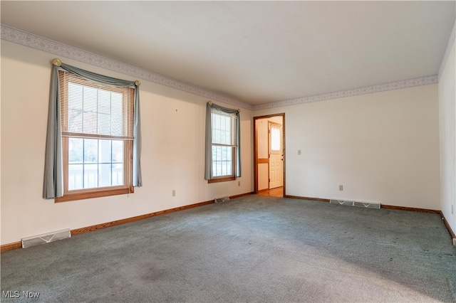 unfurnished room with crown molding and carpet