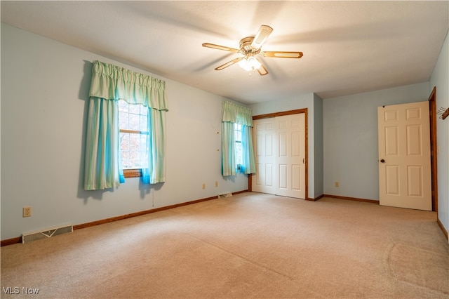 unfurnished bedroom with ceiling fan, light colored carpet, and a closet