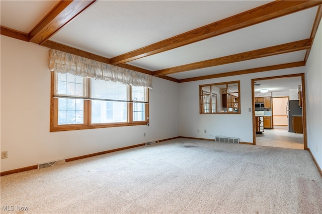 unfurnished living room with light carpet and beam ceiling