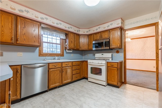 kitchen featuring a textured ceiling, sink, and stainless steel appliances