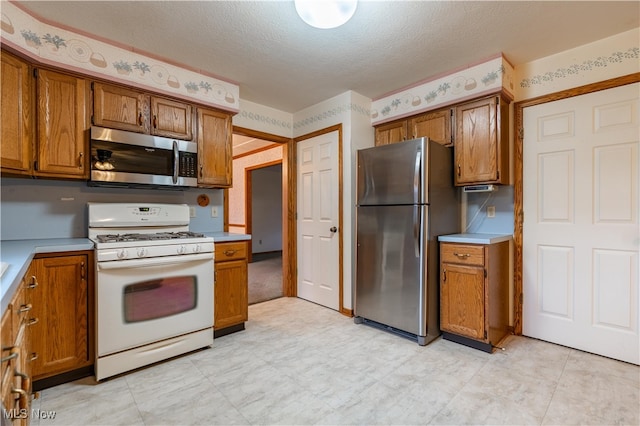 kitchen with appliances with stainless steel finishes and a textured ceiling