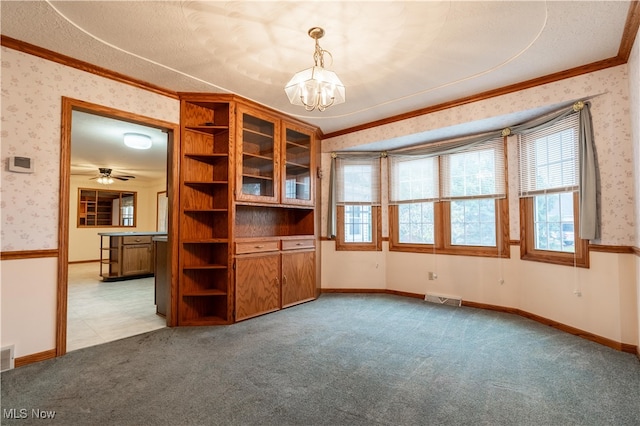 empty room featuring a textured ceiling, light carpet, crown molding, and ceiling fan with notable chandelier