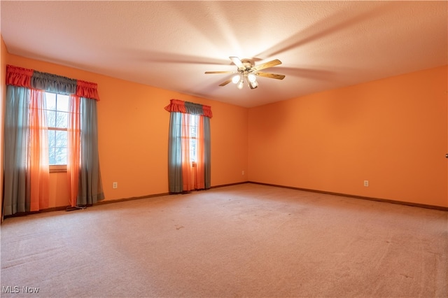 carpeted empty room featuring ceiling fan and a textured ceiling