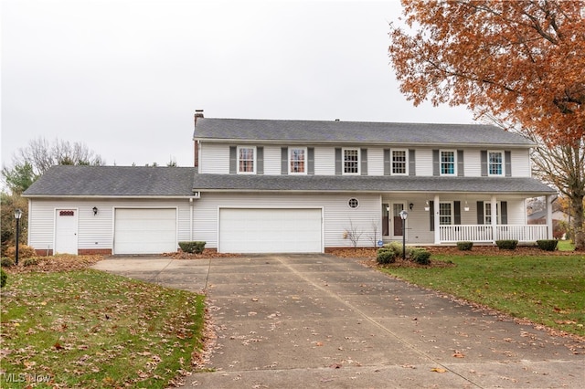 view of front facade featuring a front lawn, covered porch, and a garage