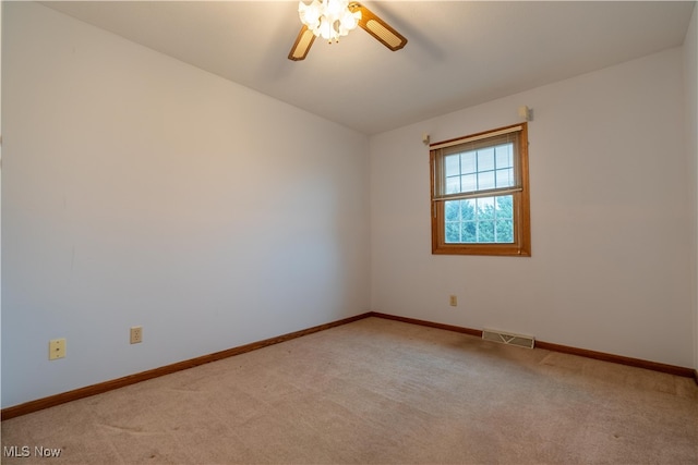 empty room with light colored carpet, vaulted ceiling, and ceiling fan