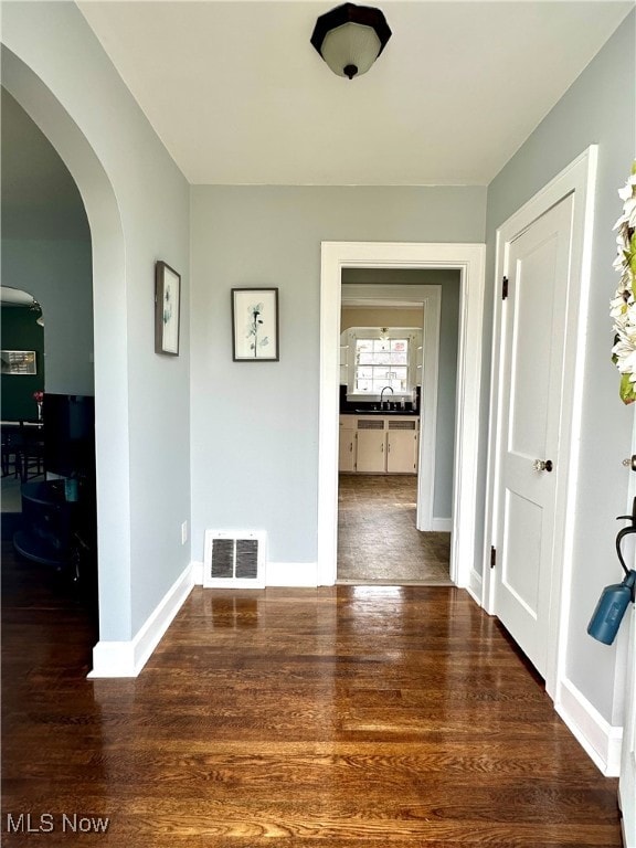 corridor with dark hardwood / wood-style flooring